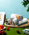 Set Of 6 Camping Kitchen Towels, 24 X 16 Inches, white dishcloths with bonfire and tent designs, displayed on a woven mat.