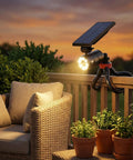 Ultra Bright Solar Motion Light Outdoor Waterproof Security Spotlight with flexible tripod on patio railing at sunset