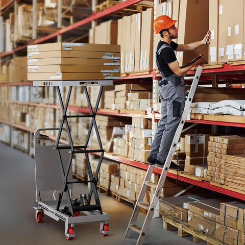 CAMMOO hydraulic lift table cart, gray, with scissor lift carrying stacked boxes in a warehouse.