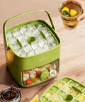 Compact Ice Cube Tray With Lid And Bin For Freezer, Mini Press Type Ice Maker, Space Saving Small Ice Bucket With Tongs For RV Office And Travel, BPA Free Green on a wooden table with ice cubes visible.