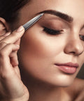 Woman using Pointed Tweezers Pro Grade High Carbon Stainless Steel Needle Nose Fine Point For Precision Hair Removal on eyebrow.