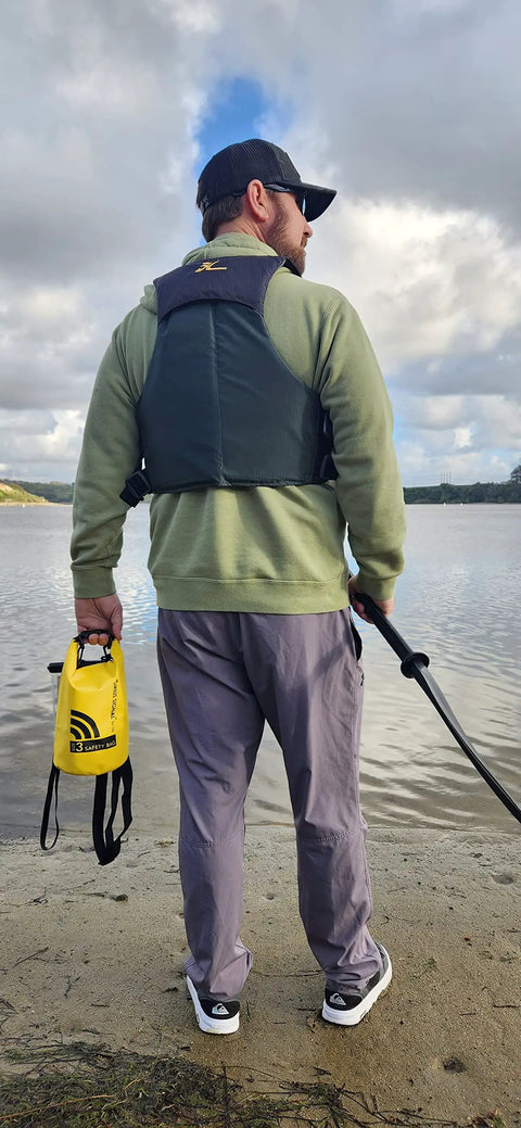 Man by lake holding All In One Boating Safety Dry Bag Kit With IP68 Waterproof Flashlight, C1004 Visual Distress Signal.