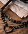 Dope Gothic Punk Leather Choker Necklace Featuring Adjustable Black Heart Chain on wooden table with newspaper background.