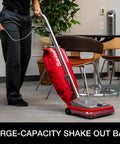 Hardcore Commercial Upright Bagged Vacuum Cleaner With Vibra Groomer Brush Roll, Fifty Foot Power Cord, Six Decked Out Height Settings, Beefy Long Life Motor, And Zero Hassle Shake Out Bags in use on low carpet.