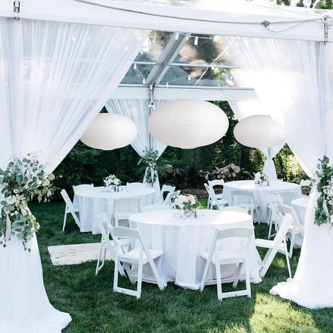 Oval Crepe Paper Lanterns 22 Inch Two Pack for Indoor Ceiling Decor at outdoor event setup with tables and chairs
