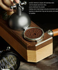 Pro Level 58mm Coffee Powder Distributor And Espresso Stirrer Tool Featuring Adjustable Height Dial Built From Food Grade Metal For Smooth Barista Extraction Plus Even Ground Bedding In Dope Gloss Black on wood base with coffee grounds.