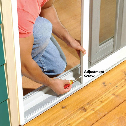 Man adjusting Heavy Duty Gliding Screen Door Roller Assembly with screwdriver on patio slider track.