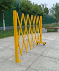 Heavy Duty Expandable Safety Barrier Gate displayed in a park, showcasing its yellow retractable metal design for traffic control.