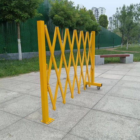 Heavy Duty Expandable Safety Barrier Gate displayed in a park, showcasing its yellow retractable metal design for traffic control.