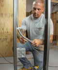 Electrician installing 3/8 In Flex 90 Degree Connector For FMC Metal Clad And Armored Cable To Steel Outlet Box Secure Bonding