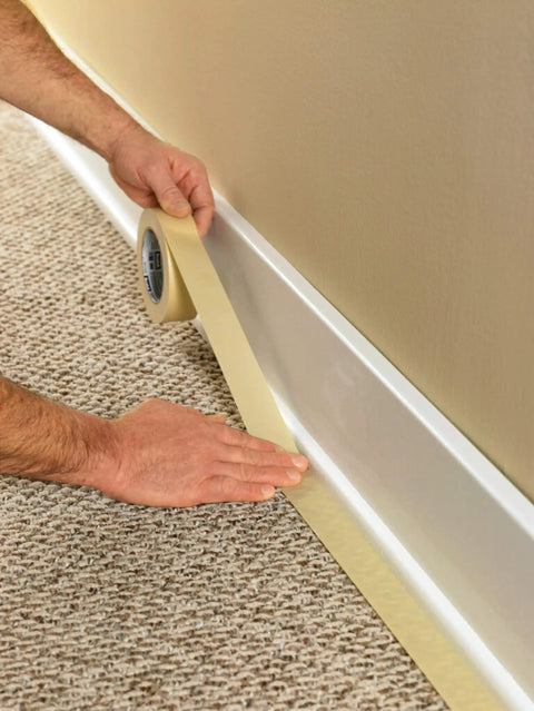 Person applying Economy Masking Tape Three Quarters Inch By Sixty Yards General Purpose Crepe Paper Backing for edging walls.