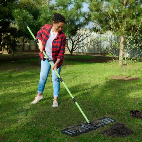 Person using Lawn Leveling Rake 30x10 Stainless Steel With 78 Inch Adjustable Handle Green Positioning Stakes Heavy Duty Leveler for backyard