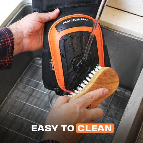 Cleaning Heavy Duty Knee Pads For Work And Home Use With Double Gel Comfort, showing water and brush on pad surface.