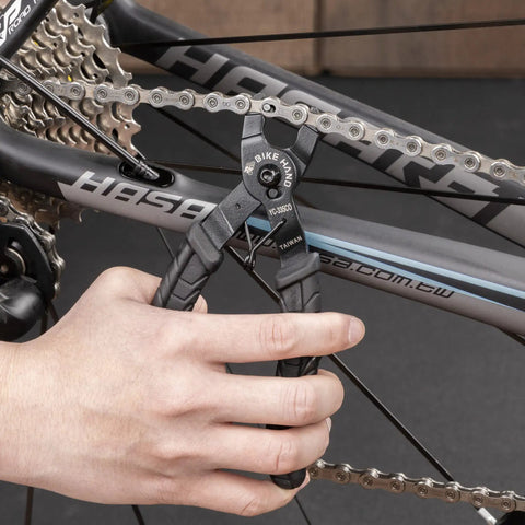 Hand using Bike Chain Master Link Pliers 2 In 1 Tool for Easy No Sweat Quick Link Removal on bicycle chain.