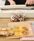 12 Inch Manual Heat Sealer With Eight Adjustable Heating Levels Handy Portable Poly Bag Sealer For Plastic PE PP Bags Easy To Use With Extra Replacement Kit Ivory Finish sealing snacks on a table.