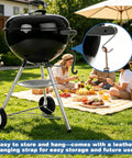 Heavy Duty Cast Iron Grill Grate Lifter For Easy No Sweat Lifting Of Heavy Grates On Charcoal And Gas Grills Universal Fit For Most Grills 8 Inch Compatible With Weber Kamado Big Green Egg And More next to a charcoal grill in a garden setting with a picnic in the background