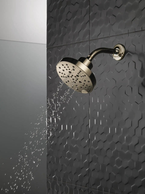 H2Okinetic 5 Setting Raincan Shower Head in Champagne Bronze with touch clean spray holes and water stream on dark tiled wall.