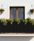 3x10 Black Fence Privacy Screen For Outdoor Shade And Balcony Decor on a balcony with hanging plants