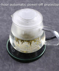 Electric Mug Warmer And Cooler For Desk Keep Your Morning Brew Or Evening Tea At A Steady 55 Degree Setting With This Super Lightweight Beverage Heater with a glass teapot on a sleek heating pad.