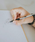 Person writing with a Heavy Duty 0.7Mm Mechanical Pencil Two Pack Designed As A Daily Driver on grid paper.