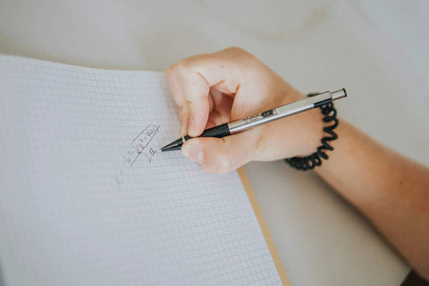 Person writing with a Heavy Duty 0.7Mm Mechanical Pencil Two Pack Designed As A Daily Driver on grid paper.