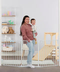 Woman holding baby next to Super Wide Configurable Baby Gate For Doorways And Open Spaces Three Panel Wall Mounted Safety Gate With Door For Babies Toddlers And Pets Expands From 28 To 76 Inches Includes Wall Mount Hardware