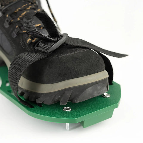 Lawn Aerator Spiked Shoes With 13 Nails Each For Lawn Aeration Scarifier Footwear Nail Shoes One Size Fits All Black Green Durable Adjustable Straps No Fuss To Use Lawn Care Tool For Healthy Green Turf on foot, showing green base and straps