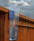 Rugged Outdoor Rain Gauge With 6 Inch Capacity For Yard Or Fence Post Mount Built Tough Weatherproof Construction Easy Install Dual Scale Inches And Millimeters For Quick Accurate Rain Readings mounted on a wooden fence in rain