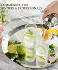 24 Ounce Cocktail Shaker Set With Bar Quality Strainer, Measuring Jigger, Mixing Spoon And Easy Recipe Guide For Beginners, Pro Grade Home Bar Kit In Silver pouring cocktails on a tray