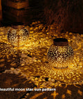 Outdoor Solar Lanterns 2 Pack Waterproof Hanging LED Lights With Metal Star Moon Sun Pattern illuminating a dark garden path.