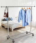 Sturdy Workhorse Commercial Grade Garment Rack With Heavy Duty Steel Construction Extends From 50 To 75 Inches Holds Up To 250 Lbs Chrome Finish Adjustable Hanging Rod For Home Office Or Studio Use image of rack in bedroom with clothes and bag.