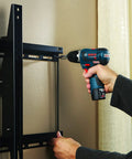 Person using 41 Piece Drill And Drive Set With Case For Wood Metal And Masonry Projects GoTo Bit Kit to install wall mount.