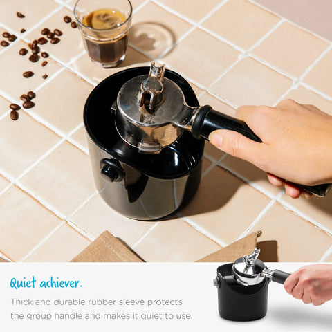 Hand holding a portafilter over Grindenstein Espresso Knock Box Sturdy and Compact Black Coffee Grounds Container, modern design