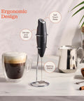 Game Changing Handheld Milk Frother Wand Battery Operated Stainless Steel Drink Mixer For Milk Coffee Lattes Cappuccino Frappe Matcha Hot Chocolate With Stand Gift, shown on stand next to coffee and milk accessories.