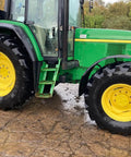 Green tractor with large tires parked on a concrete surface, suitable for cleaning with Touchless Heavy Equipment Cleaner One Step Detergent Soap Concentrate Foam For Construction Gear And Work Trucks No Brushing Commercial Grade Auto Foam Cleaner Dilutable Easy Rinse One Gallon.