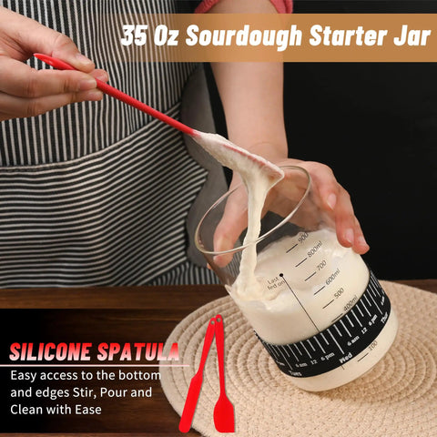 Complete Sourdough Starter Jar Kit 35 Oz Large Glass Jar with red silicone spatula stirring dough in marked jar