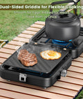 Two Burner Foldable Camp Stove With Dual Surface Griddle showing steak and egg cooking on grill next to teapot on burner