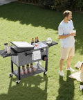 80 Quart Rolling Ice Chest With Divider Holds 110 Cans Or 50 Bottles Portable Outdoor Drink Cart With Bottom Shelf Foldable Side Shelves Swivel Wheels Beer Cooler Party Bar On Wheels Bottle Opener in a garden setting with people.