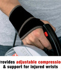 Person using a saw while wearing adjustable compression wrist support brace with moderate joint relief for weak sore or injured wrists