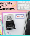 Badass Date Stamp Featuring Custom Text Options And Dual Blue Red Ink With A Legit Gray Mount on a colorful desk backdrop.