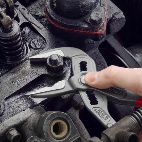 Hand using Cobra ES Extra-Slim 10 Inch Pump Pliers With Narrow Jaws for gripping round parts in machinery maintenance