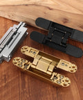 Heavy Duty Six Inch Hidden Door Hinges Two Pack Three Way Adjustable Invisible Concealed Hardware With Sleek Gold Finish displayed on wood.