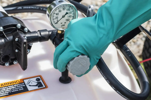 Person adjusting pressure gauge on Tow Behind Sprayer With 60 Gallon Capacity, 4 GPM Diaphragm Pump, 100 PSI