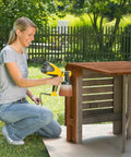 Person using Control Spray Max HVLP Paint and Stain Sprayer With Fully Adjustable Settings For Decks Cabinets Furniture And Woodworking Includes Extra Container In Bright Yellow And Black For A Smooth Finish On Thin Materials on outdoor furniture