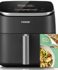 Six Quart Nine In One Air Fryer With Pfas Free Ceramic Basket And Fast Air Technology on kitchen counter with recipe book.