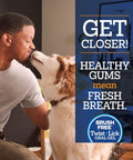 Dog and owner indoors with text promoting Dog Dental Gel That Cleans Teeth And Freshens Breath All Day For Your Pup With Peanut Butter Flavor 2 Oz 30 Day Supply Easy To Use Gel That Adheres To Gums For Quick At Home Dental Care.
