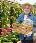 Gardener holding wooden crate with vegetables and gardening tools in greenhouse