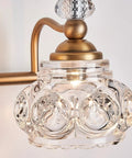 Close-up of vintage brass vanity light fixture for bathroom lighting with ornate glass shade, classic antique look.