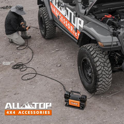 Heavy Duty 12V Dual Cylinder Portable Air Compressor Kit inflating off-road truck tire at outdoor location