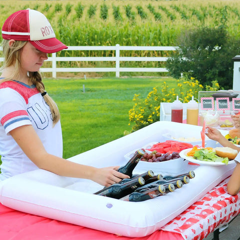Person using Three-Piece Inflatable Serving Bars Set With Drain Plug And Pump, Ice Cold Bar For Food And Drinks at outdoor picnic.